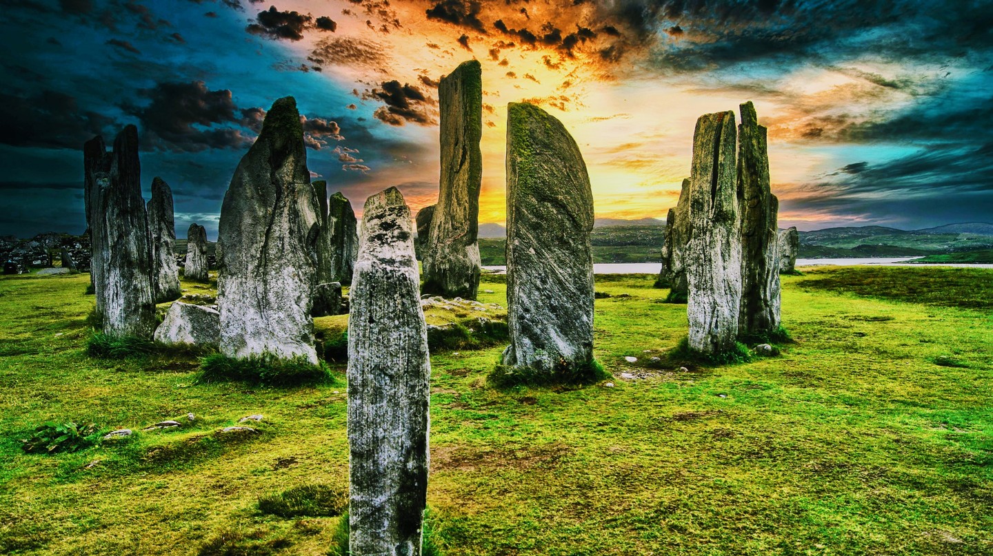 Callanish Standing Stones Circle Vivid Green Grass Dramatic Sunset Sky Scotland